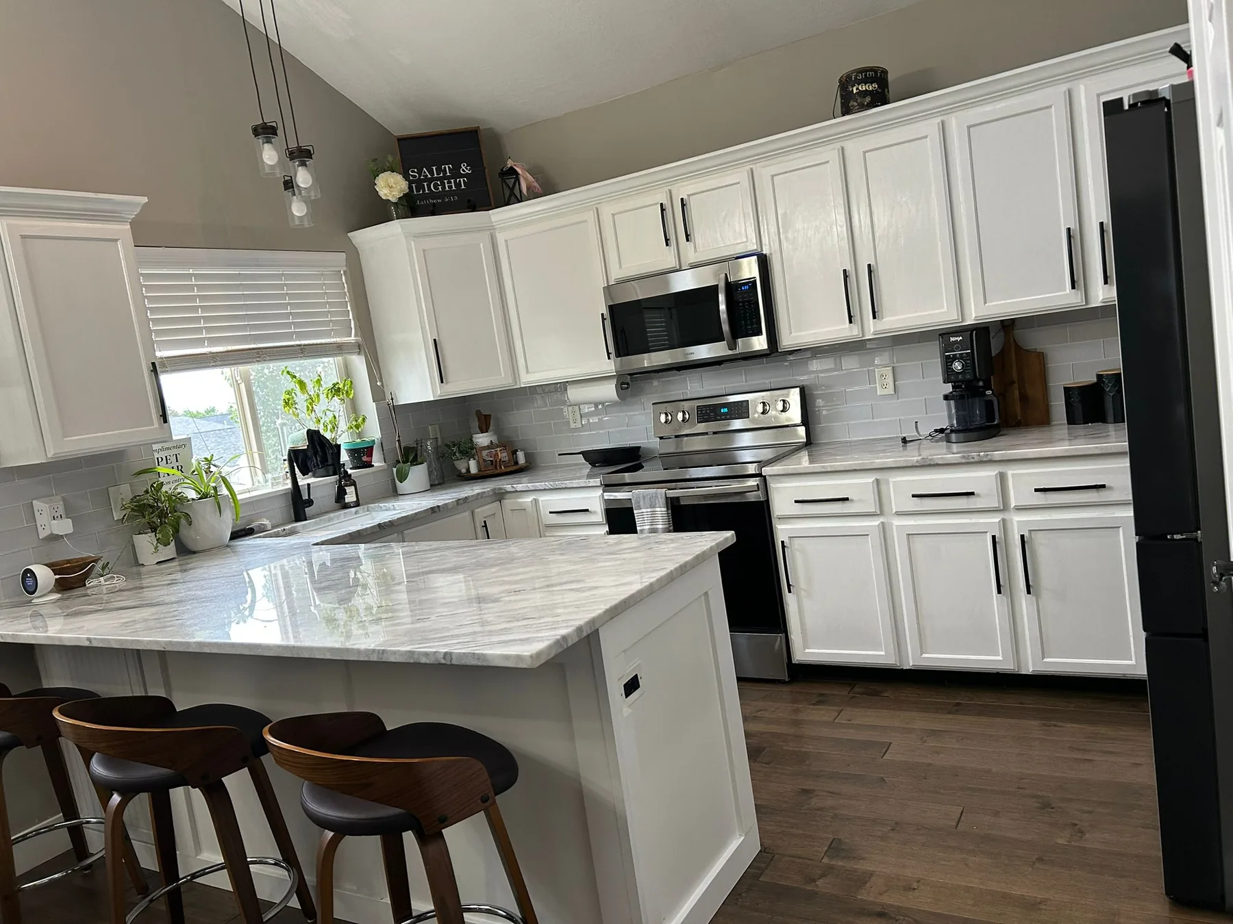 Bright, freshly cleaned kitchen with white cabinets and polished marble countertops